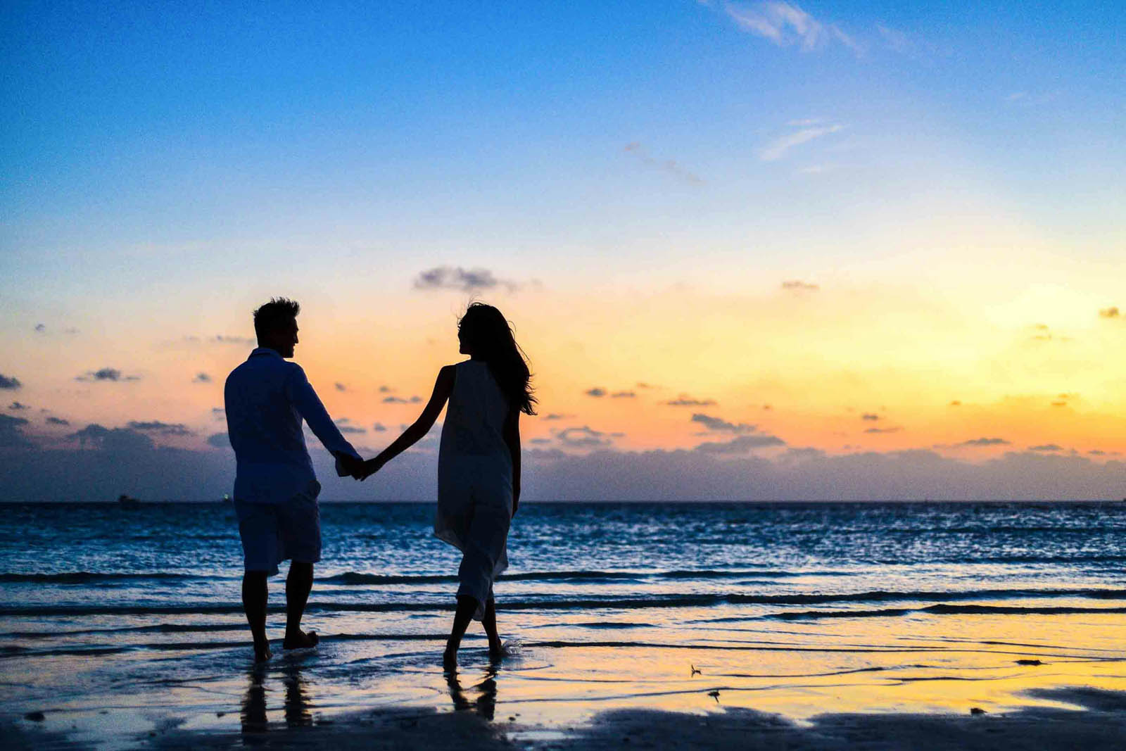 Maryland beach skyline with a early morning walker couple after online relationship therapy in Maryland and DC with Dr. Gloria Vanderhorst’s telehealth practice that offers Online Couples Therapy in DC and MD
