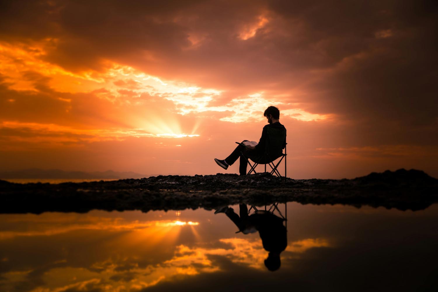 Man sitting on the water with an observation glass, symbolizing curiosity and self-understanding in Maryland and DC.