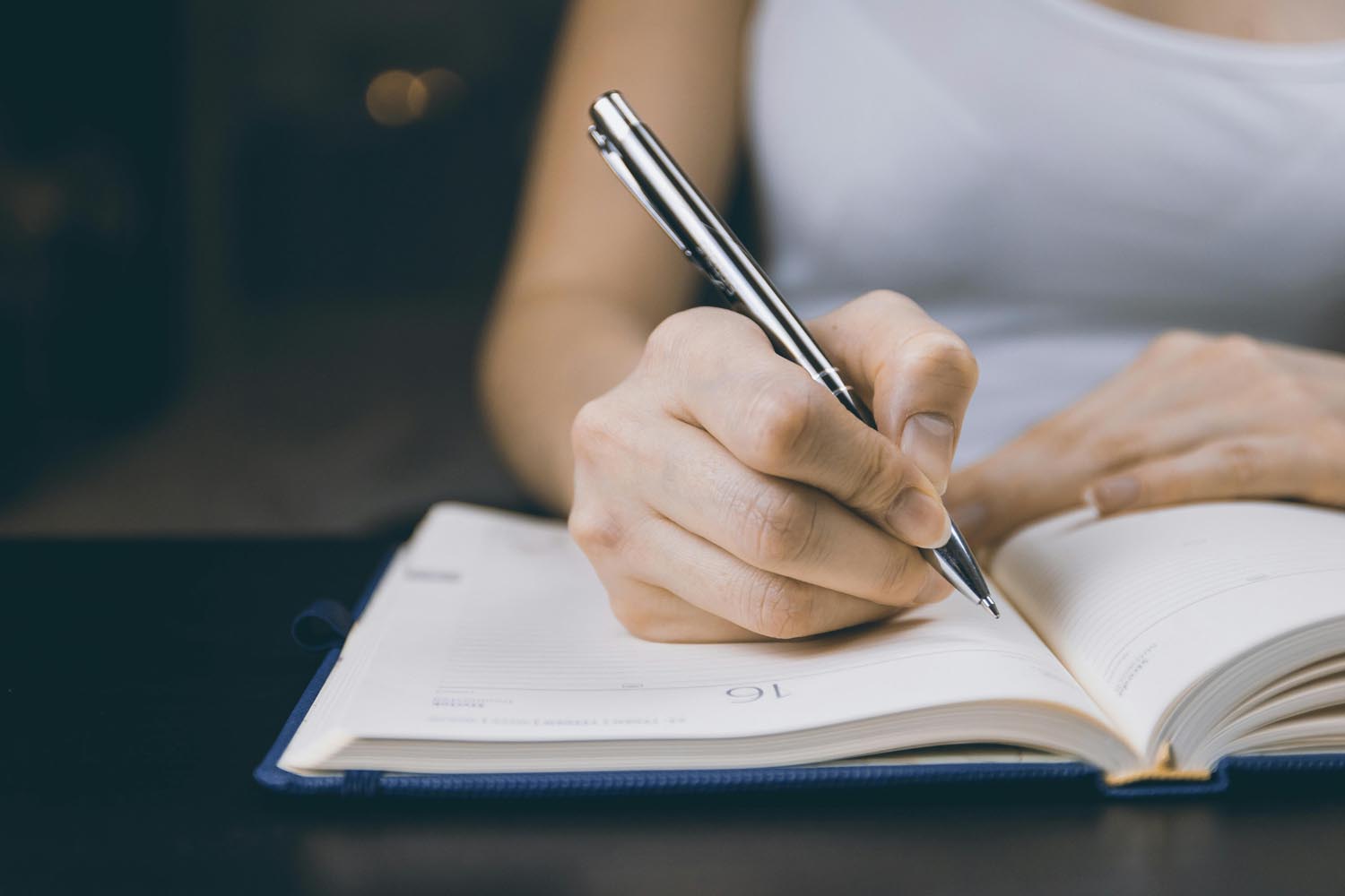 A journal and pen beside a steaming mug, symbolizing year-end reflection and emotional renewal in Maryland and DC.
