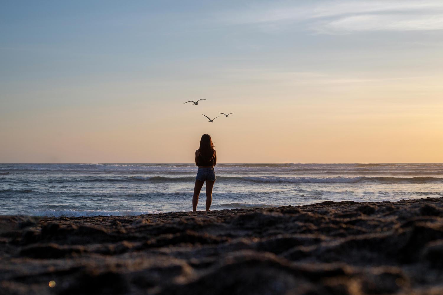 A person looking out over the ocean with a questioning expression, symbolizing self-deception and emotional reflection in Maryland and DC.