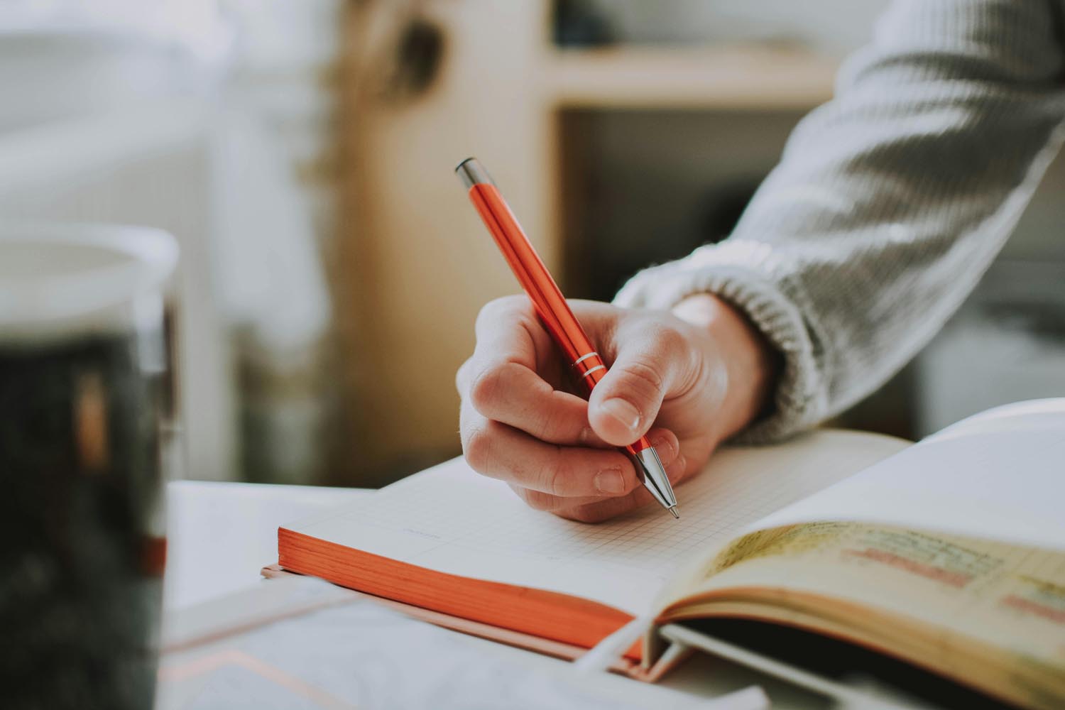 Woman writing in an old-school notebook, symbolizing nostalgia, emotion, and reflection in Maryland and DC.