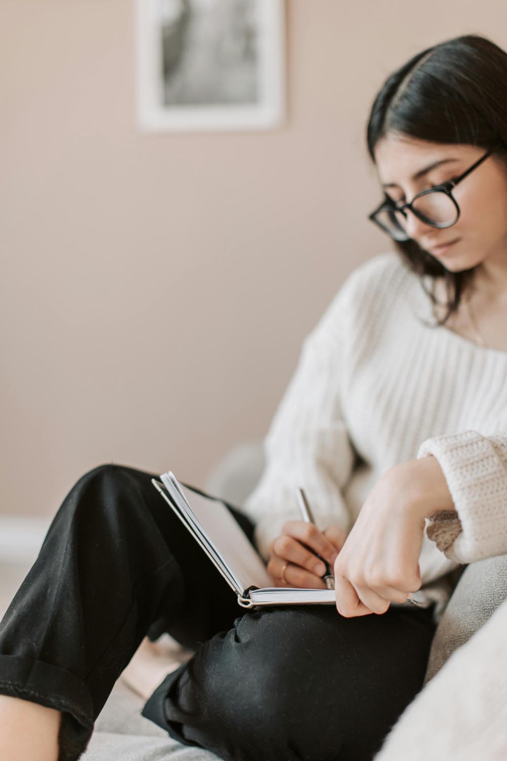 Person journaling about cravings beside a window before a meeting, symbolizing introspection and emotional depth in therapy in Maryland and DC.